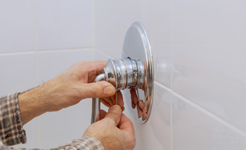 a man removing single unit shower handles image